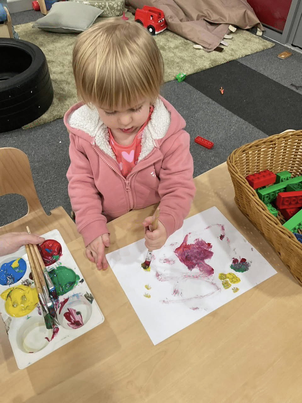 little girl painting in a nursery