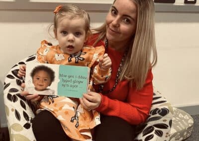 Staff with a child helping with Welsh language learning