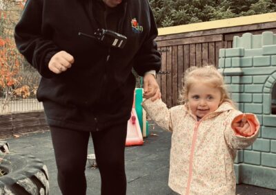 nursery staff playing outside with toddlers