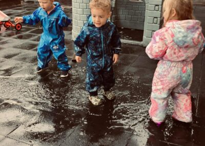 Toddlers outside playing in puddles